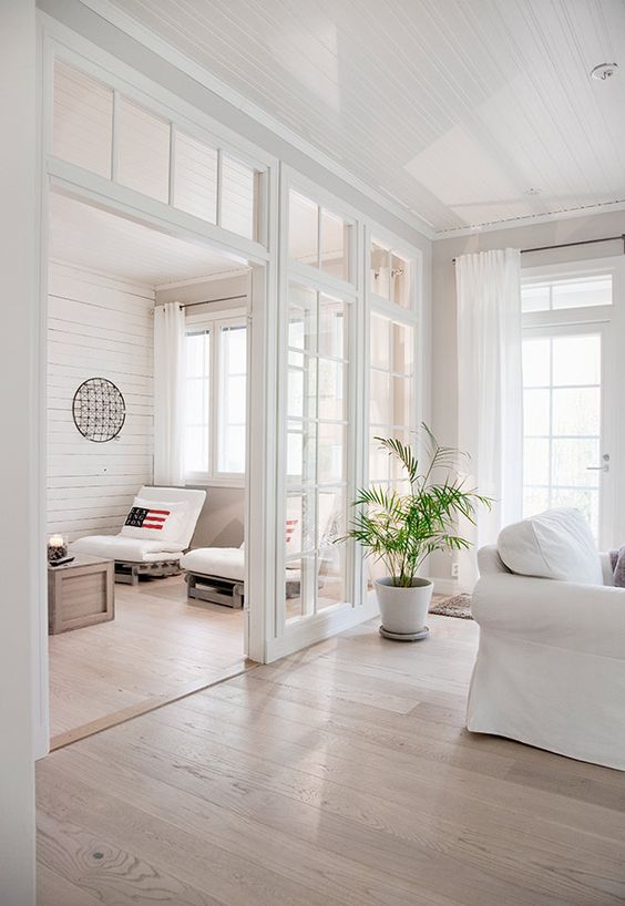 Interior glass wall design adding brightness and architectural elegance between open-plan living areas.